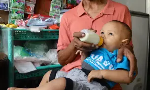 A child is bottle-fed formula milk