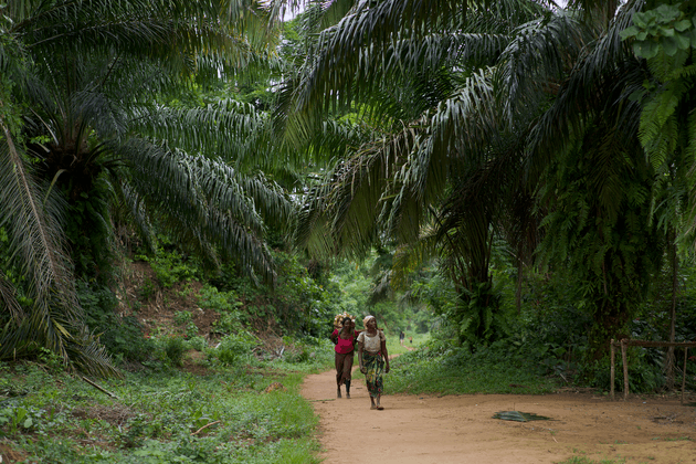 Two people walking through Baringa village