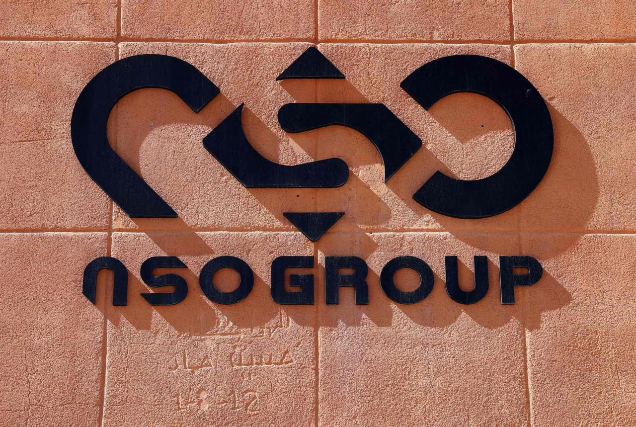 The NSO logo in black against a red brick wall