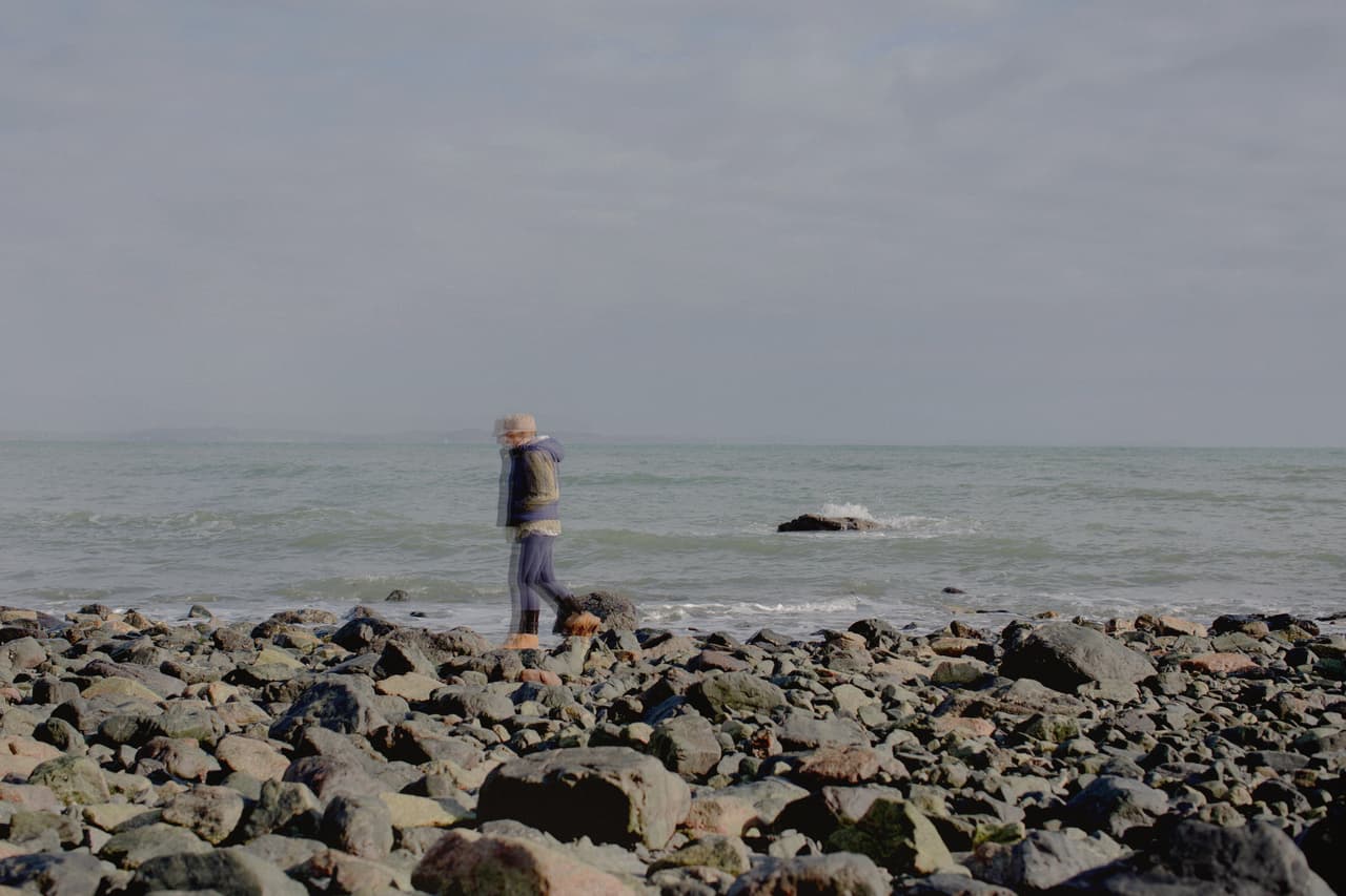 An anonymous woman walks on the coastline
