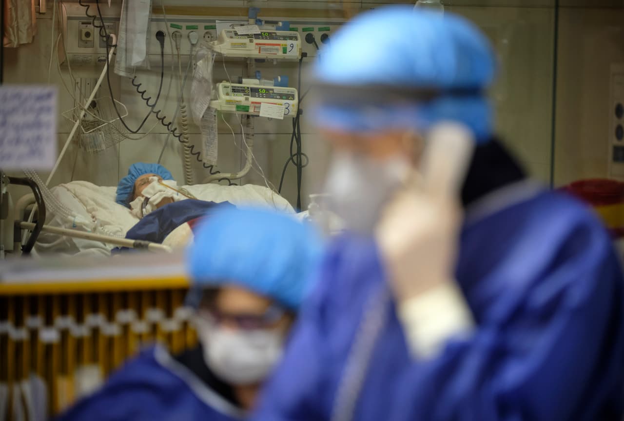 A patient in intensive care and two doctors in scrubs
