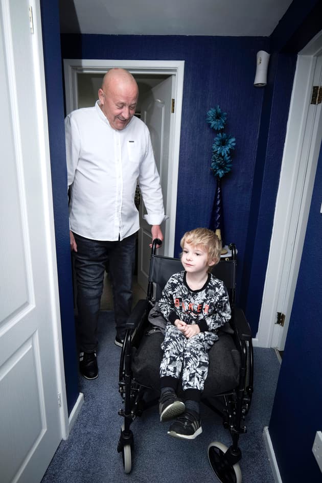 Peter smiles as his grandson sits in his wheelchair