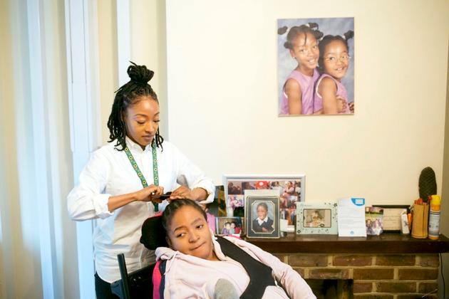 Lauren brushes Rianna’s hair in the living room of their home