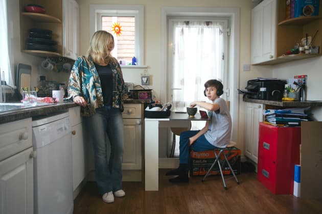 Sam and his mother, Julie Rae, stand in the kitchen while eating a bowl of cereal