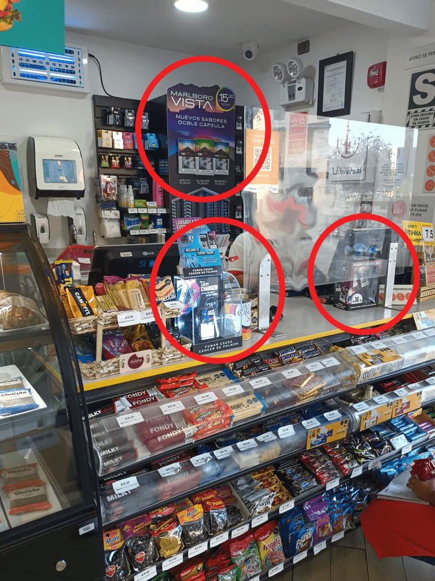 Cigarette boxes are displayed next to sweets, chocolates and crisps in a bodega in Peru