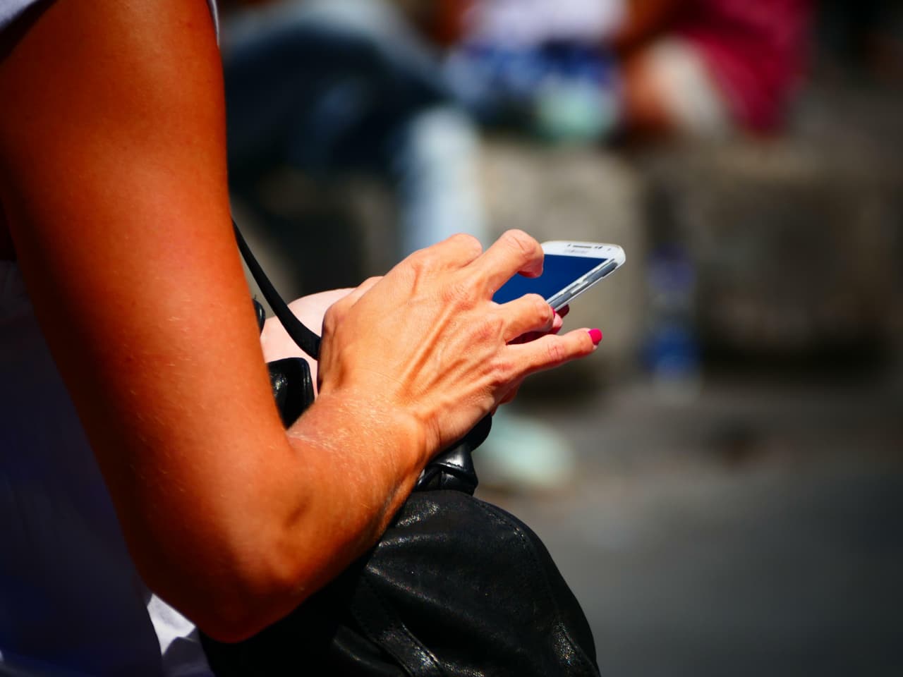 A woman checks her SMS messages and emails on a smartphone