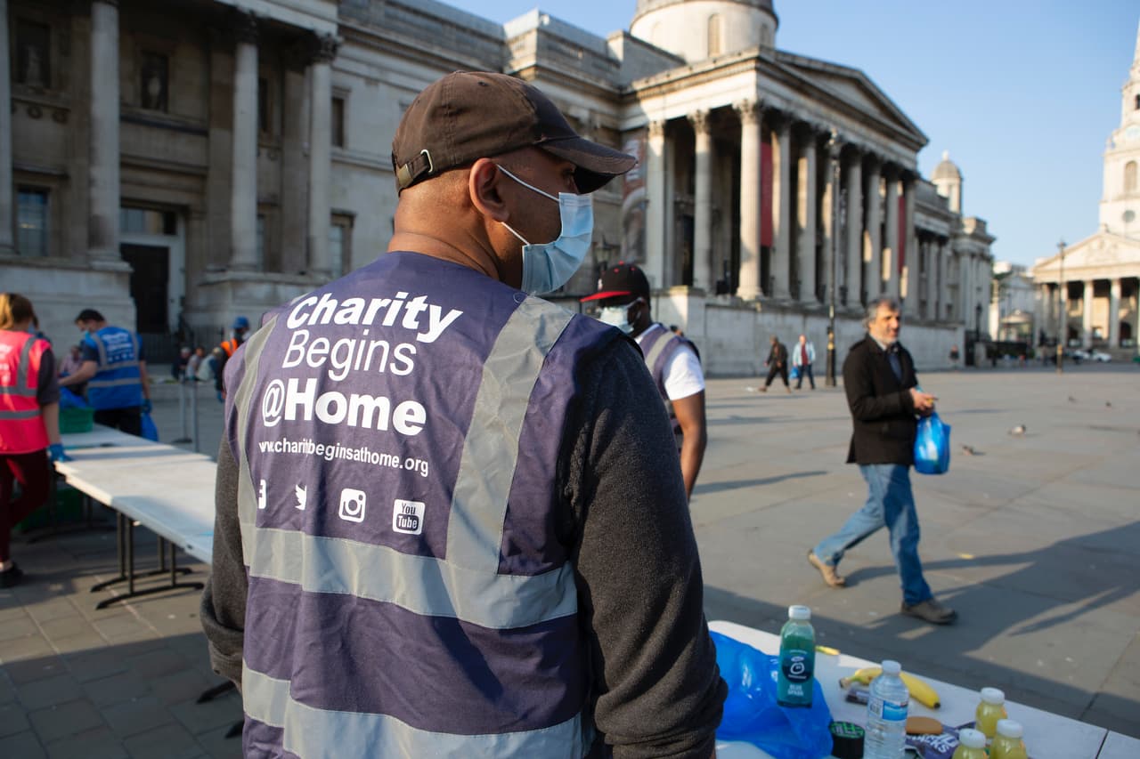 A charity worker hands out food and drink in Trafalgar Square