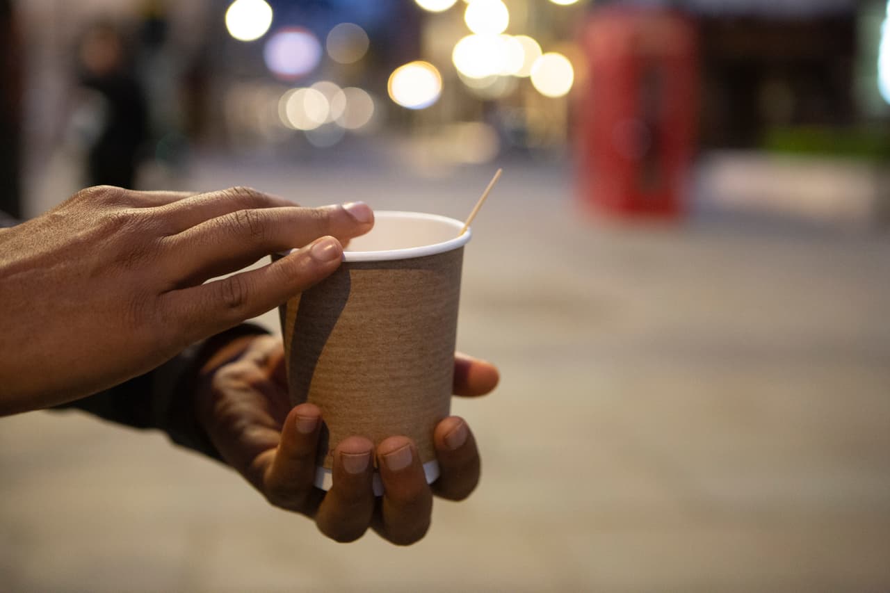 Hands holding a disposable coffee cup