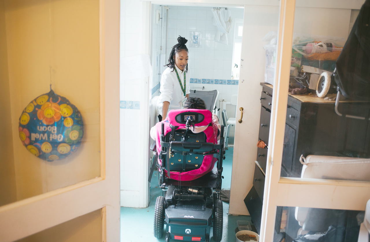 Lauren Campbell-Thompson helps twin sister Rianna into the bathroom of their Bromley home